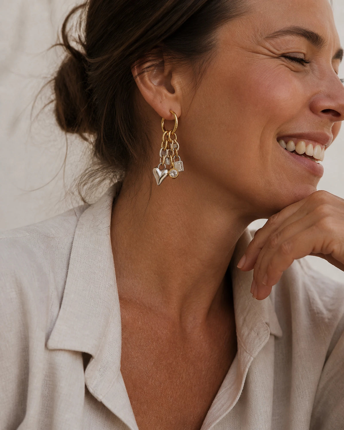 Woman laughing in coastal light wearing MAREA Heart Lock Drops