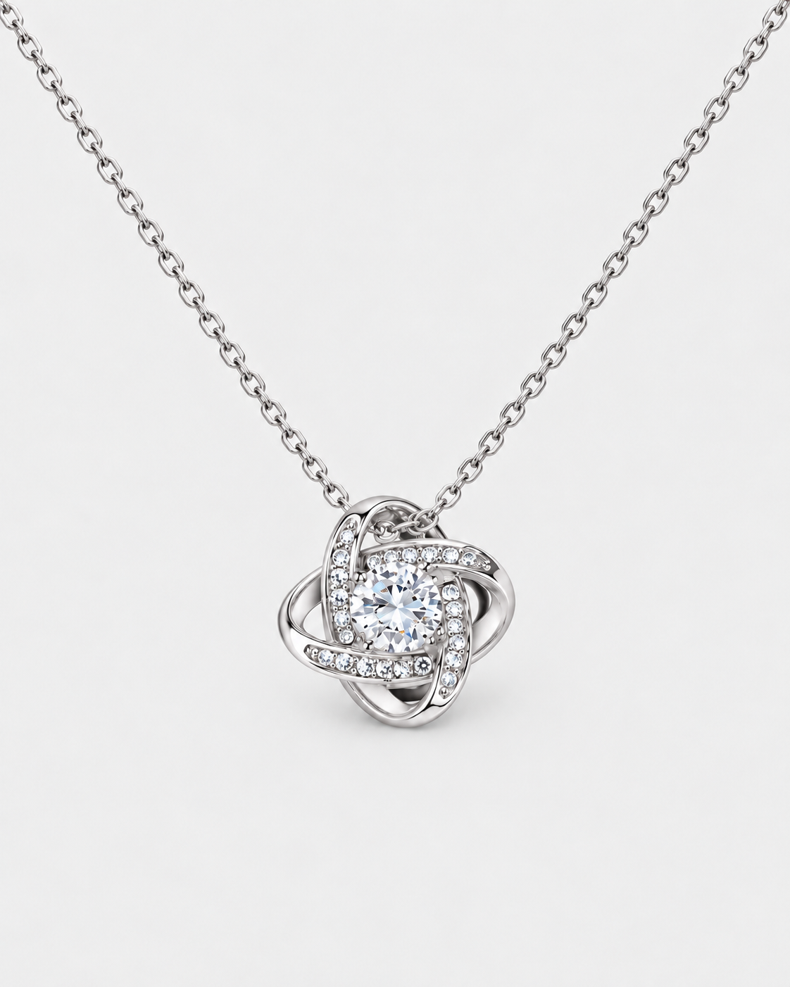 Love Knot necklace in silver-tone stainless steel on a light grey background