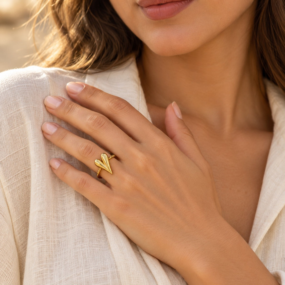 Woman wearing the MARÉA Heart Twist Ring gold ring