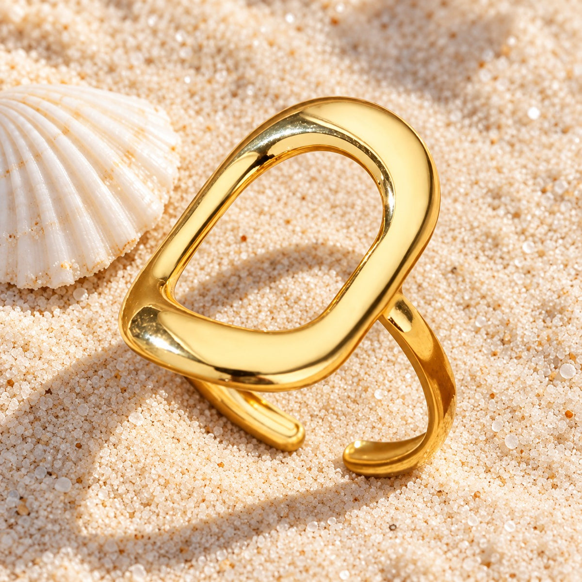 MARÉA Oval Ring gold ring with a large open oval face on sand with a shell