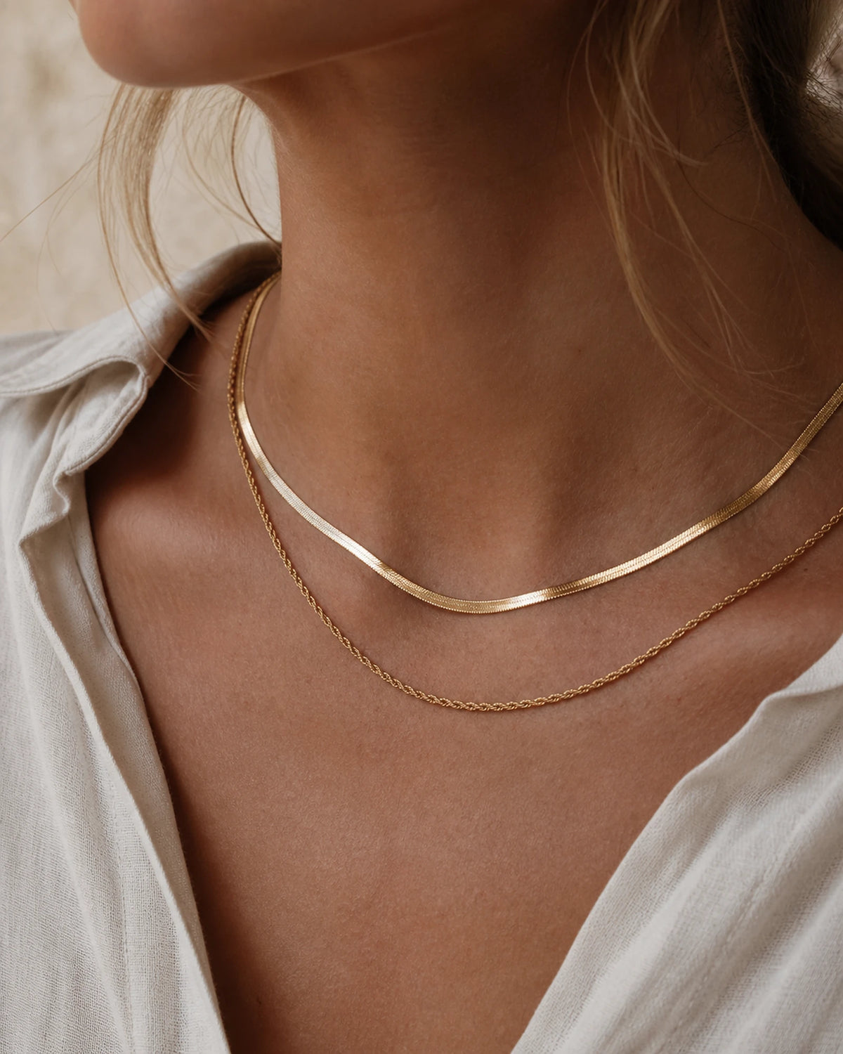 Woman wearing the gold MAREA Harbor Chain layered at the collarbone