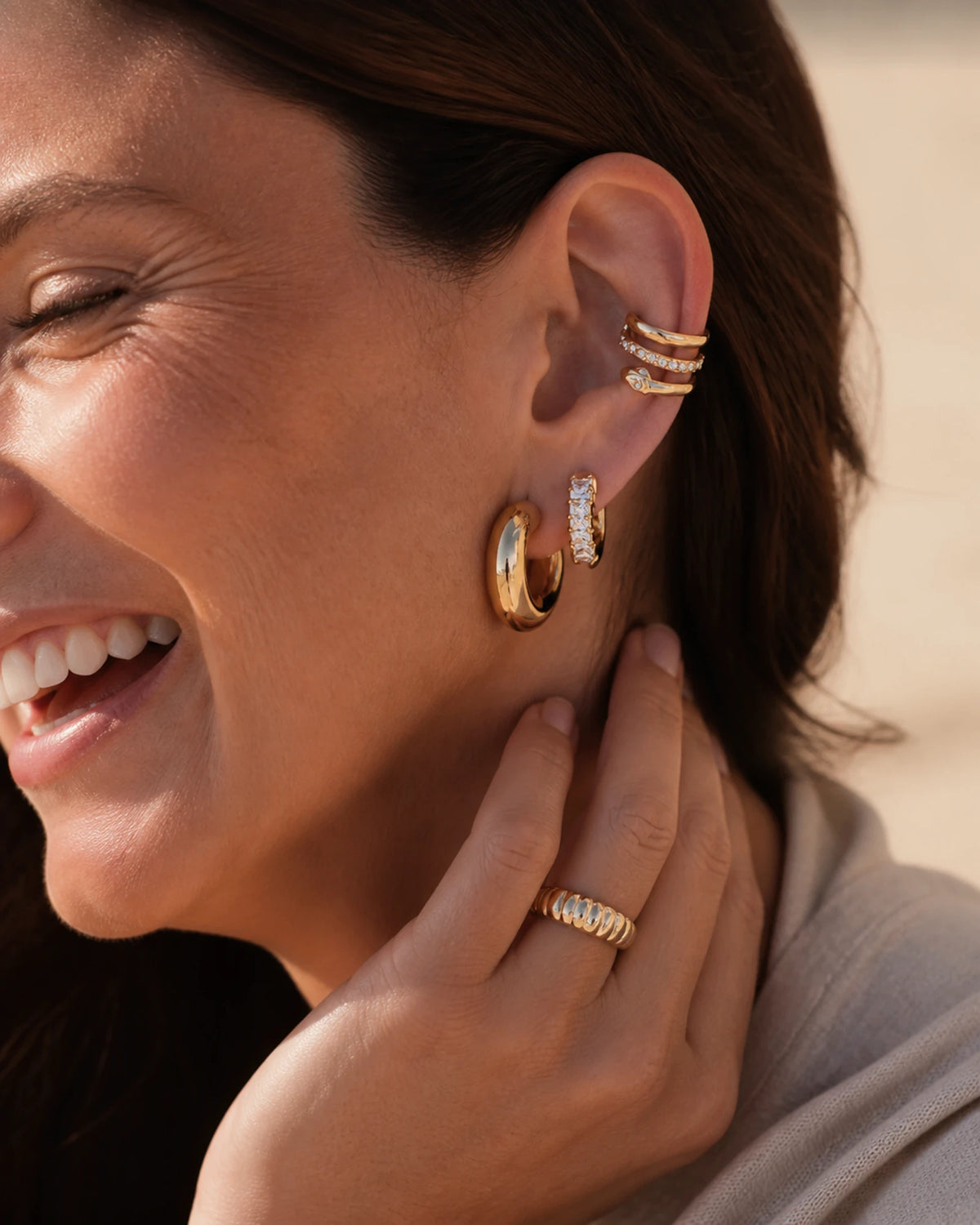 Woman laughing in coastal light wearing the MAREA Horizon Stack
