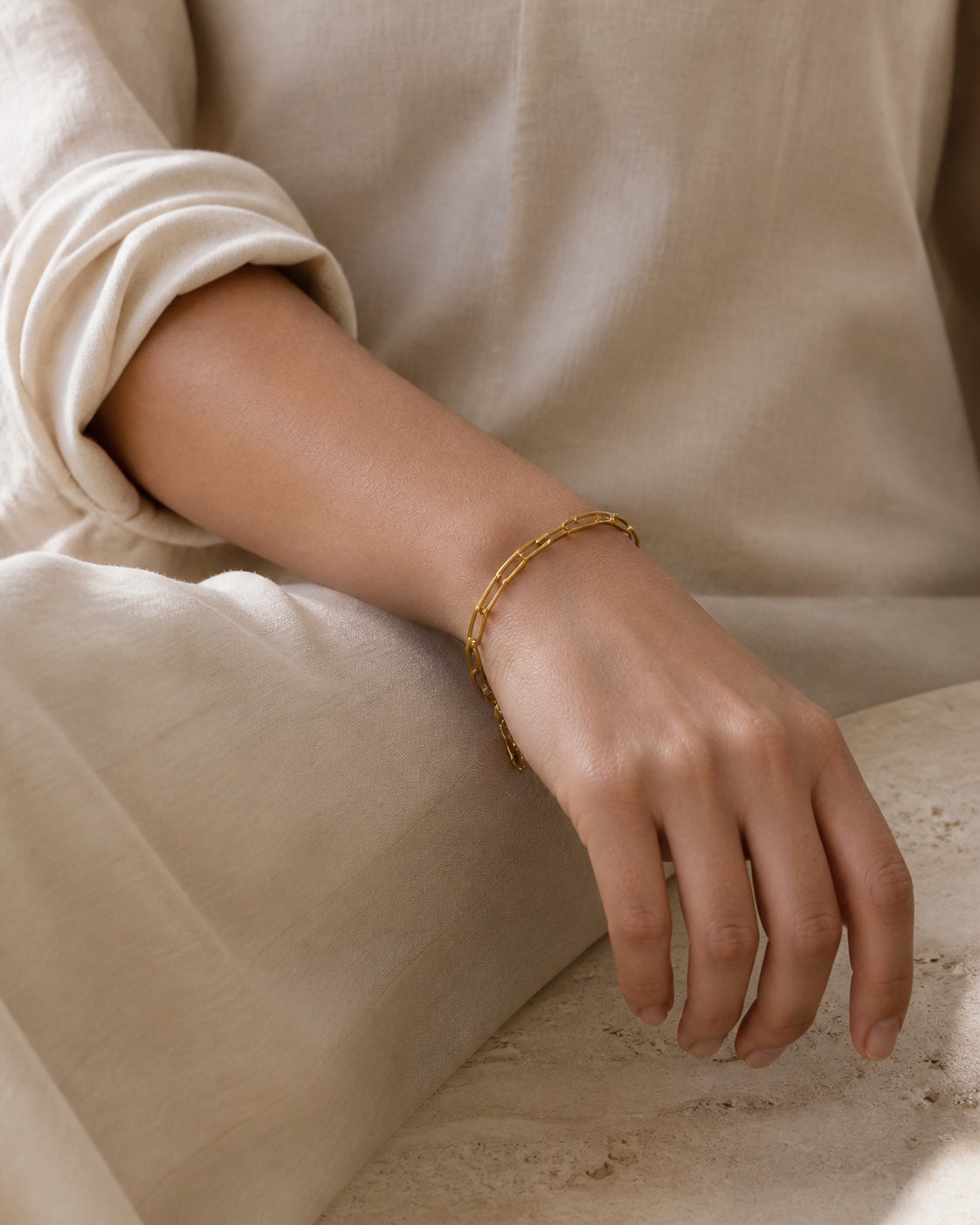 Woman wearing the gold MAREA Paperclip Bracelet on her wrist