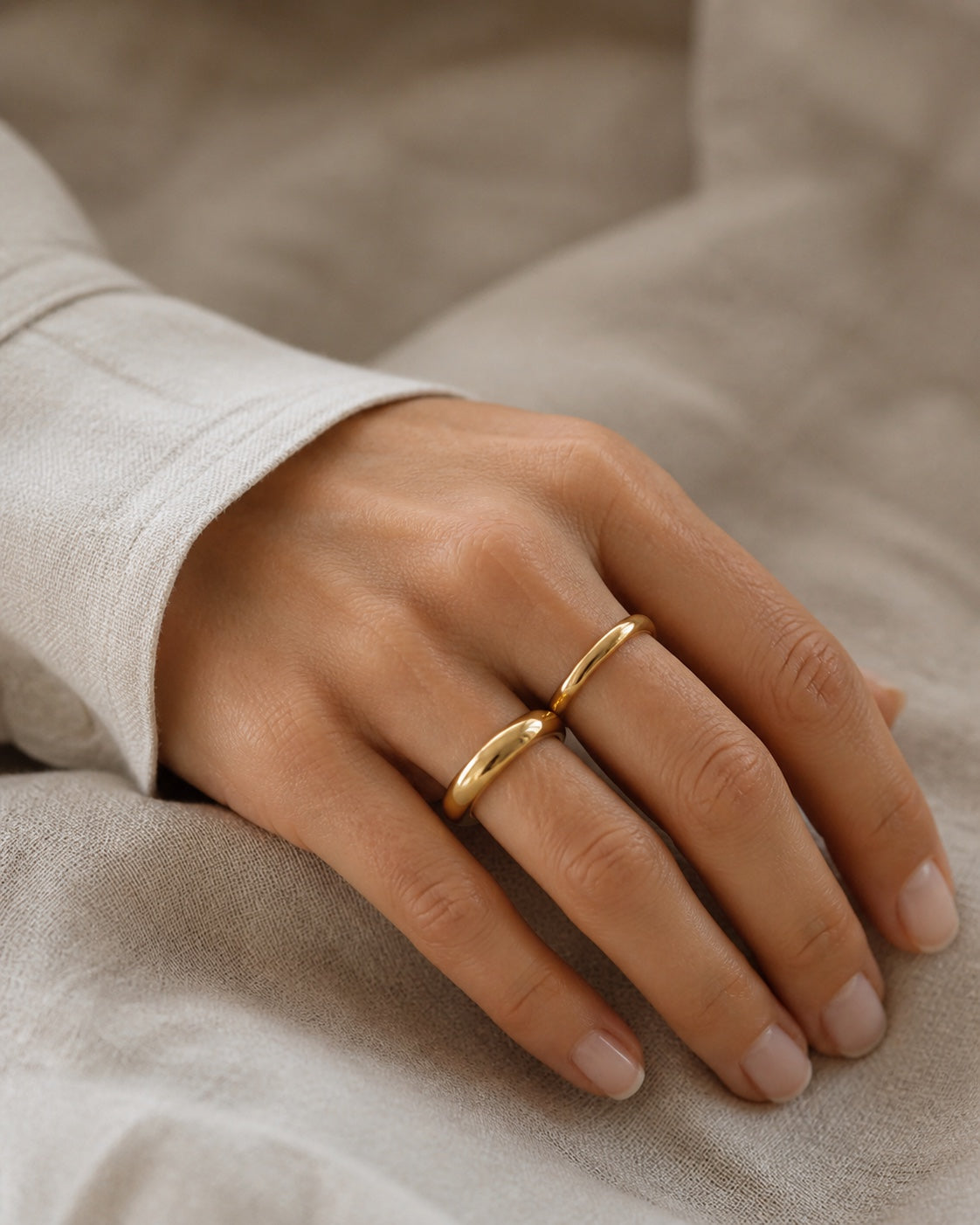 Woman wearing the gold MAREA Ripple Set rings on her hand