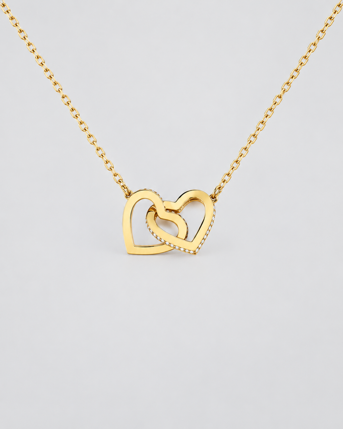 Connected Hearts necklace in gold-tone on a light grey background