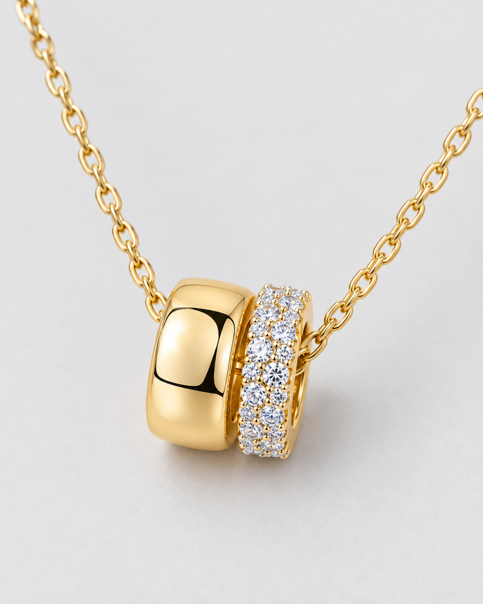 Close-up of the Eternal Rings pendant with sparkling zirconia stones, gold-tone finish