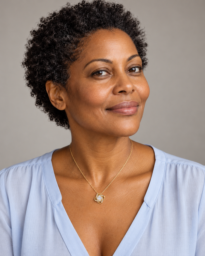 Woman wearing the Love Knot necklace, gold-tone finish