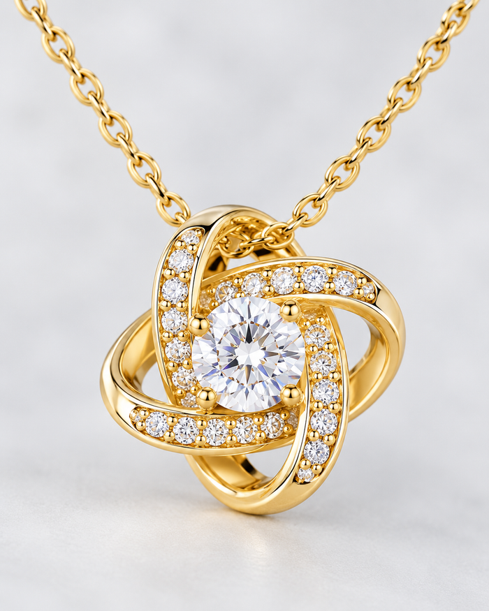 Close-up of the Love Knot pendant with sparkling zirconia stones, gold-tone finish