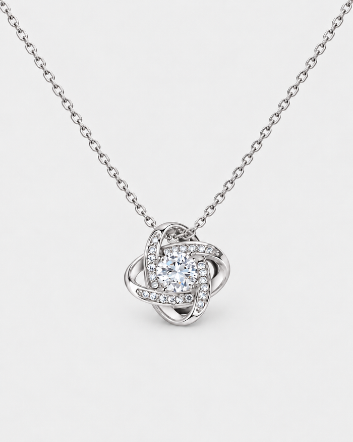 Love Knot necklace in silver-tone finish on a light grey background