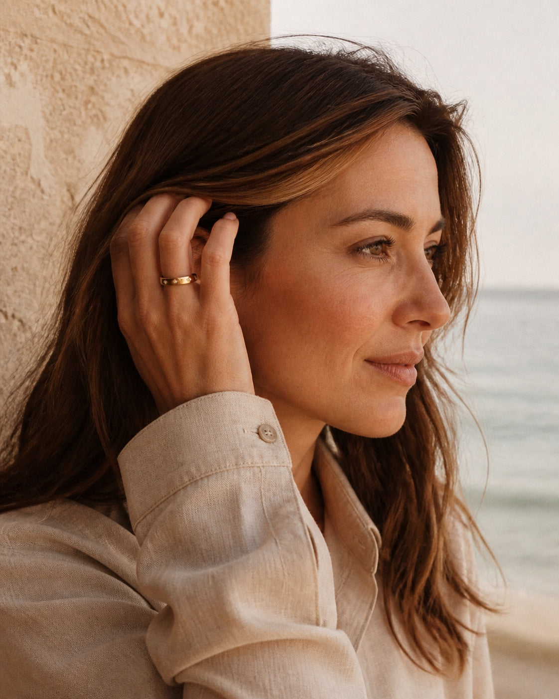 Woman in coastal light wearing the gold MAREA Eternity Ring