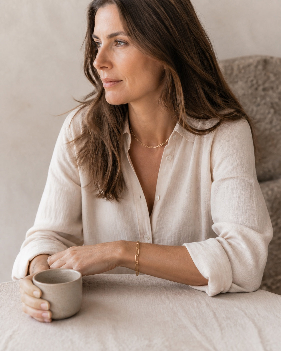 Woman with a coffee wearing the gold MAREA Paperclip Bracelet